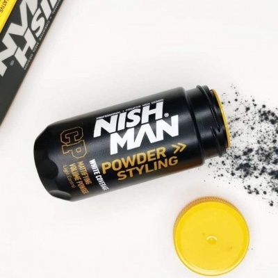 Pó de cabelo NISH MAN em embalagem preta com tampa amarela e pó espalhado ao lado