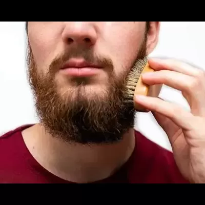 Homem a pentear a barba com escova de madeira