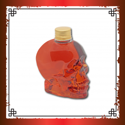 Garrafa em forma de caveira com líquido vermelho alaranjado e tampa dourada
