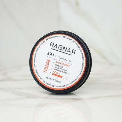 Cera para cabelo RAGNAЯ com tampa preta sobre mármore branco