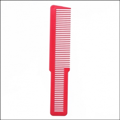 Pente vermelho com dentes largos e finos sobre fundo branco