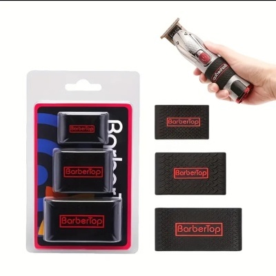 Suportes e tiras pretas com texto BarberTop em vermelho ao lado de máquina de cortar cabelo