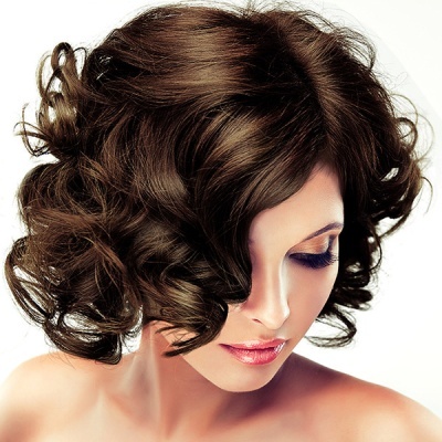 Mulher com cabelo castanho escuro encaracolado em fundo branco