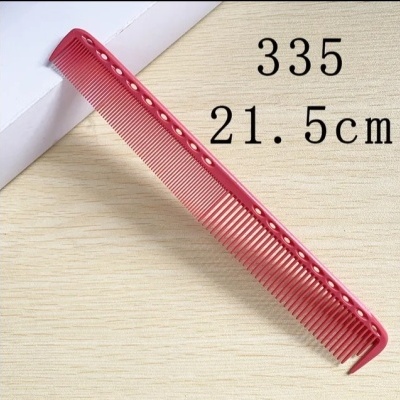 Pente vermelho de plástico com furos e dentes finos de 21.5 cm sobre superfície clara