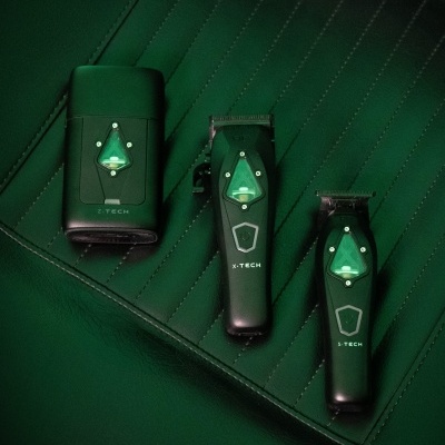 Máquinas de cortar cabelo pretas e verdes sobre superfície verde acolchoada