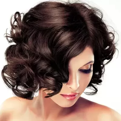 Mulher com cabelo castanho escuro ondulado e maquilhagem clara