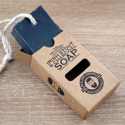 Sabonete preto em barra com cordão branco em embalagem de cartão castanho