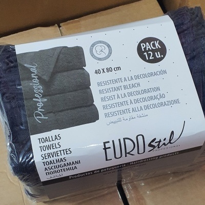 Pacote de 12 toalhas cinza escuro Eurostil Professional embaladas em plástico sobre caixa de cartão.