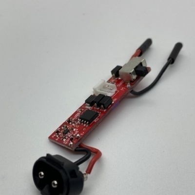 Placa eletrónica vermelha com componentes, botão branco e conector preto com fios.