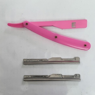 Navalhete rosa com lâminas metálicas sobre superfície branca