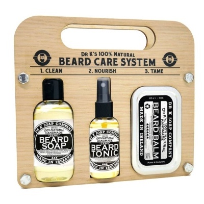 Conjunto de cuidados para barba DR K'S com sabão, tónico e bálsamo apresentados num suporte de madeira clara.