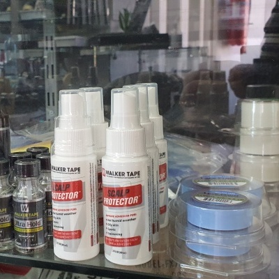 Produtos em frascos e fitas adesivas sobre uma prateleira de vidro