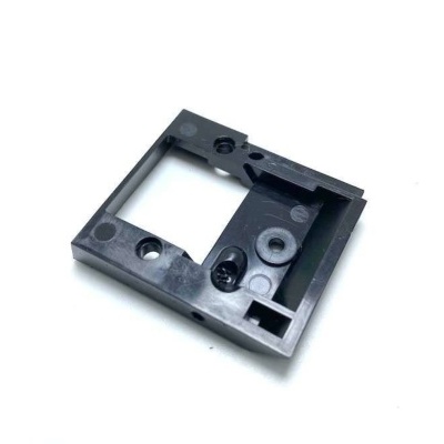 Peça quadrada de plástico preto com recortes e furos