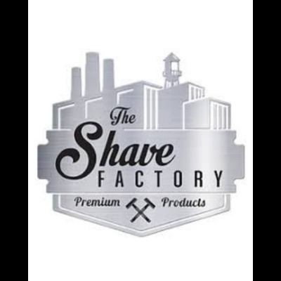 Logótipo metálico cinzento da The Shave Factory com texto e silhuetas industriais.