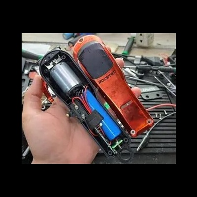 Aparelho portátil vermelho BOOSTER com tampa removida mostrando componentes internos