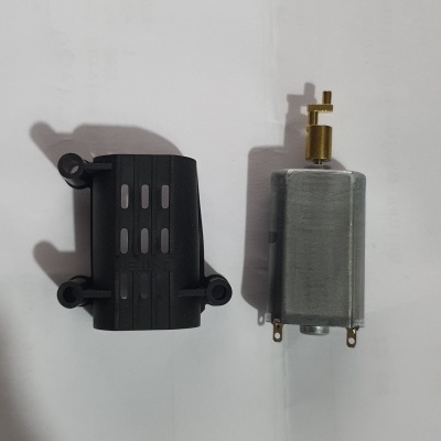 Motor elétrico cinza com capa plástica preta ao lado