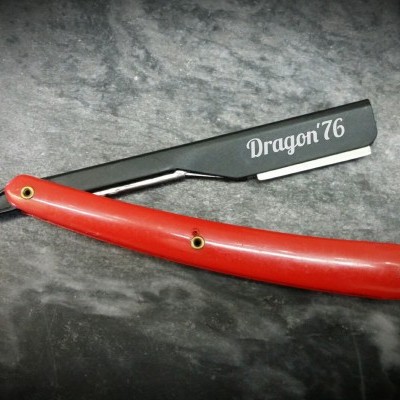 Navalha de barbear com cabo vermelho e lâmina preta com texto 'Dragon 76'