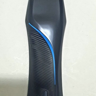 Parte traseira de aparelho elétrico preto com faixa azul e texto em relevo WAHL