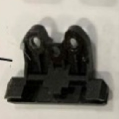 Peça plástica preta com buracos circulares e extensões planas