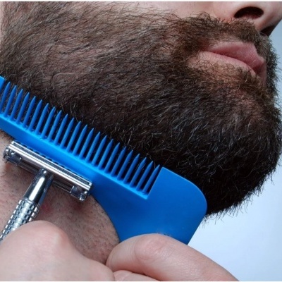 Homem a aparar barba com pente azul e lâmina metálica