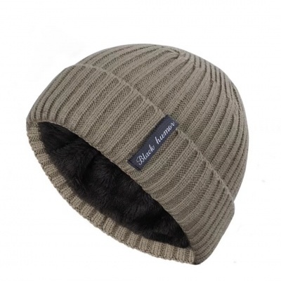 Gorro de malha bege com interior felpudo preto e etiqueta preta com texto branco