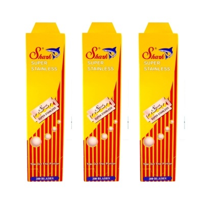 Três embalagens amarelas e vermelhas de lâminas de barbear Shark SUPER STAINLESS