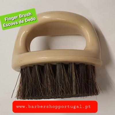 Escova de dedo com cabo bege e cerdas escuras sobre fundo branco