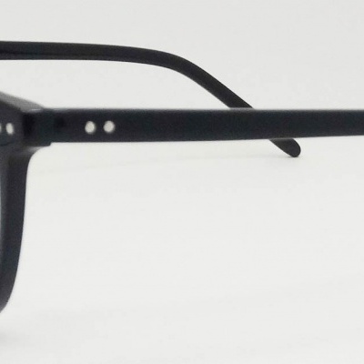 Óculos de grau com armação preta arredondada e hastes finas.