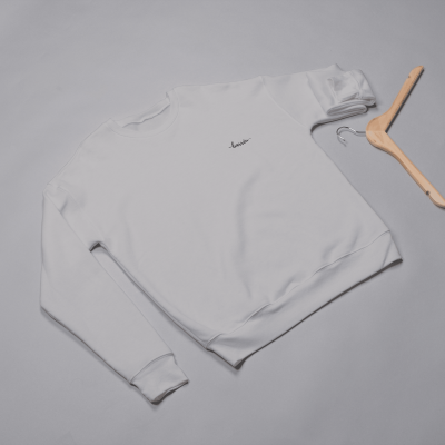 Sweatshirt branca com texto 'Savoir' bordado em preto e cabide de madeira ao lado