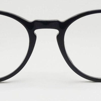 Óculos de armação redonda preta sobre fundo branco.