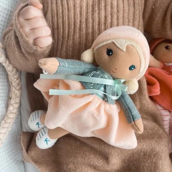 Boneca de tecido com roupa verde-azulada e saia cor de salmão