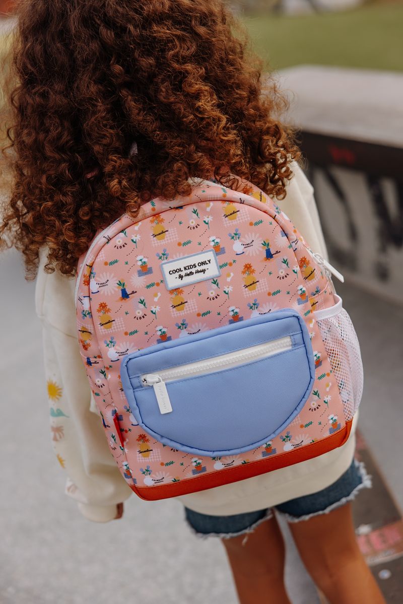 Mochila infantil rosa com padrão de plantas e bolso azul