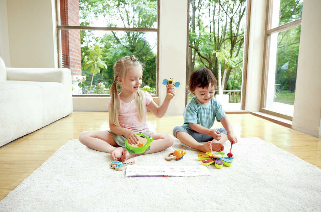 Crianças a brincar com brinquedos de madeira coloridos num tapete branco