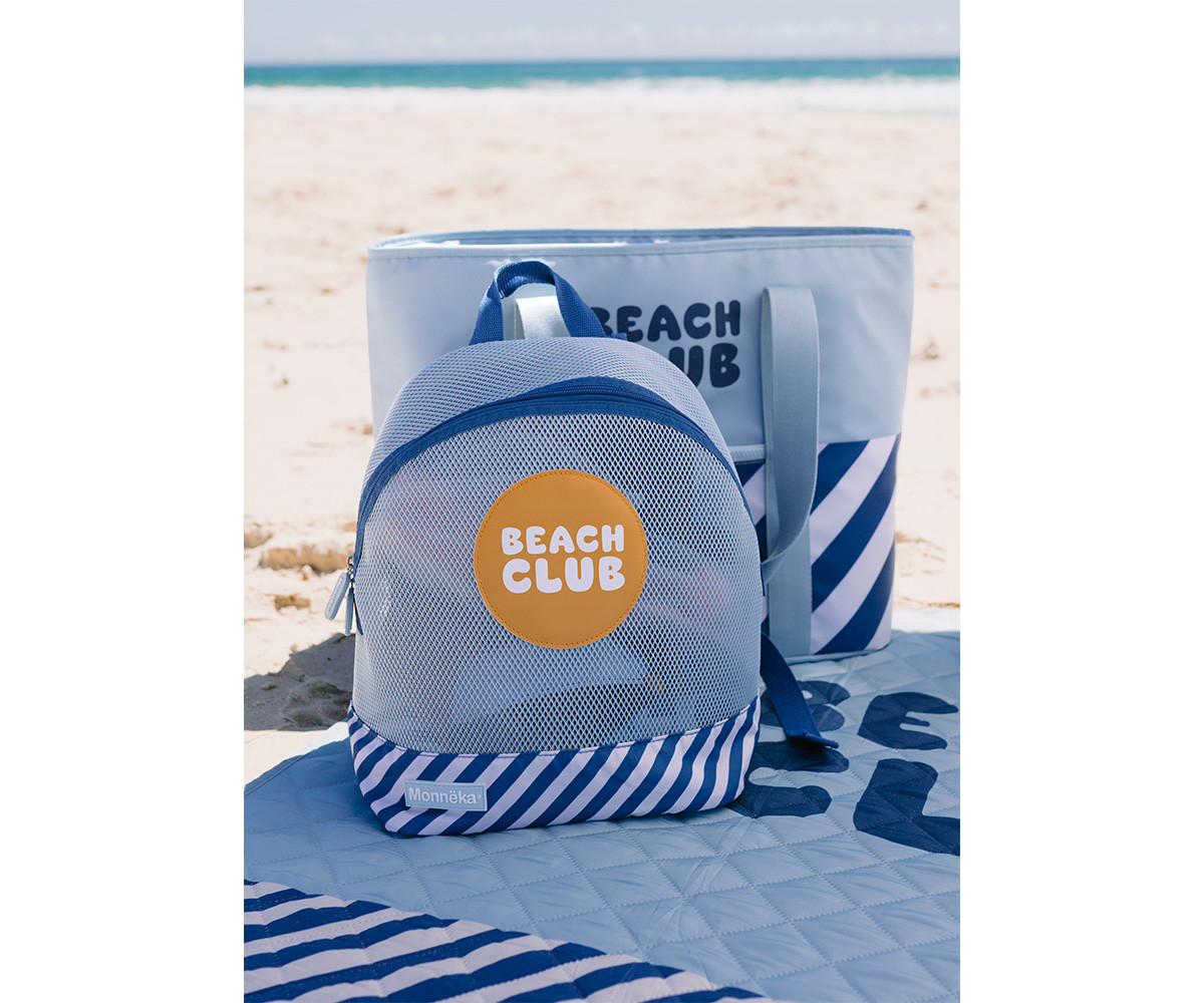 Mochila azul com bolsa de praia azul claro e riscas azuis na areia