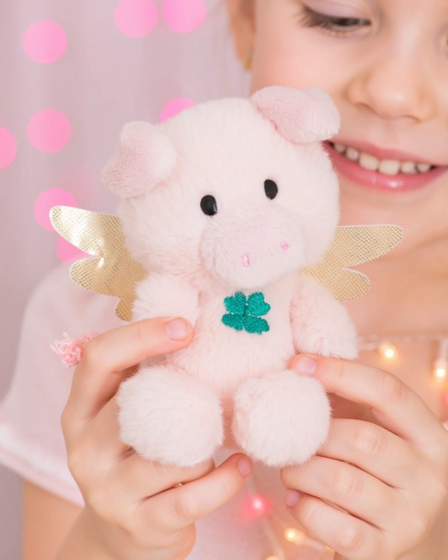 Pelúcia de porco rosa claro com asas douradas e trevo verde