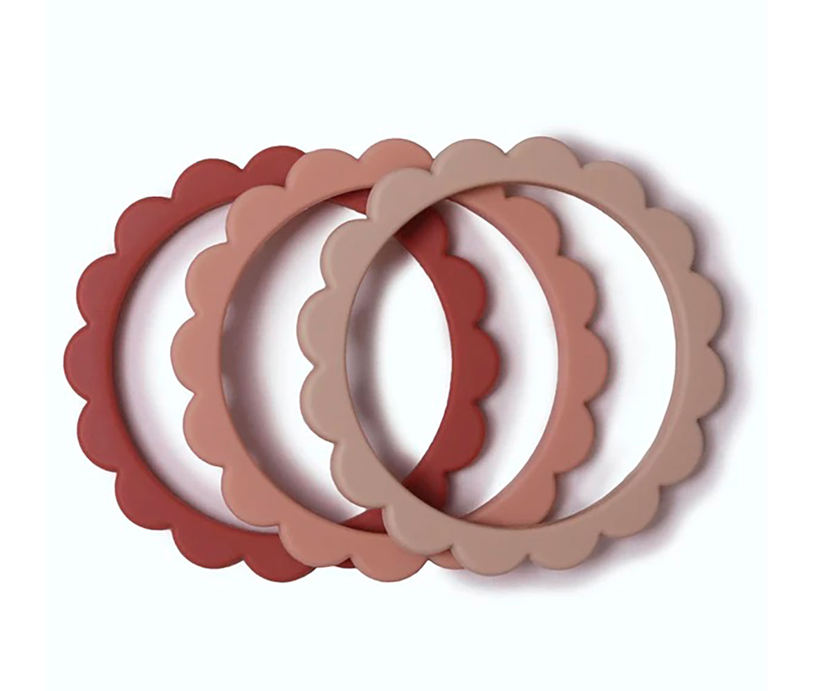 Três pulseiras de silicone onduladas em vermelho, rosa e bege sobre fundo branco