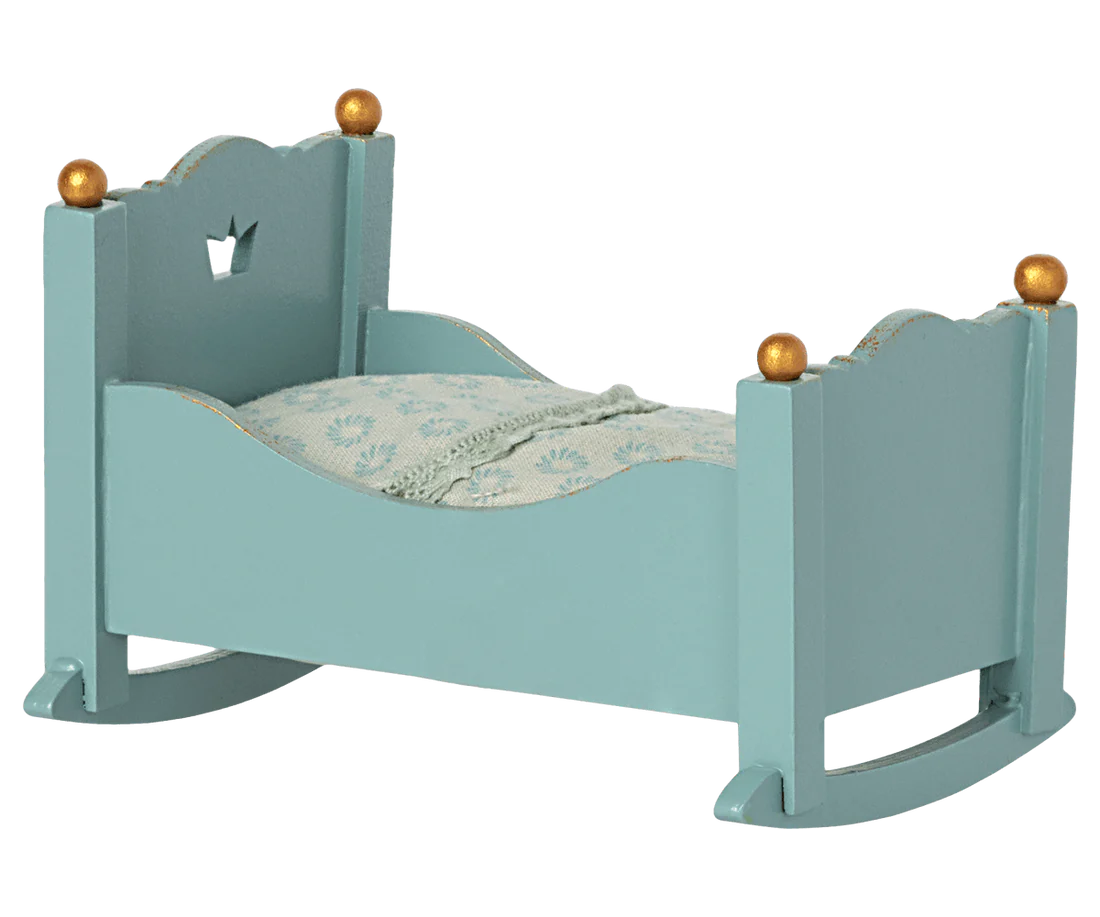 Berço de madeira azul claro com detalhes dourados e edredão branco azul