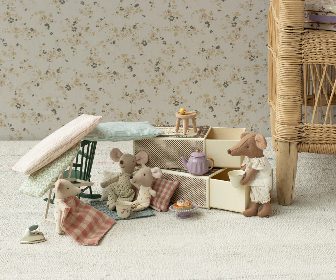 Bonecos de rato em tecido com móveis de brinquedo em ambiente com papel de parede floral