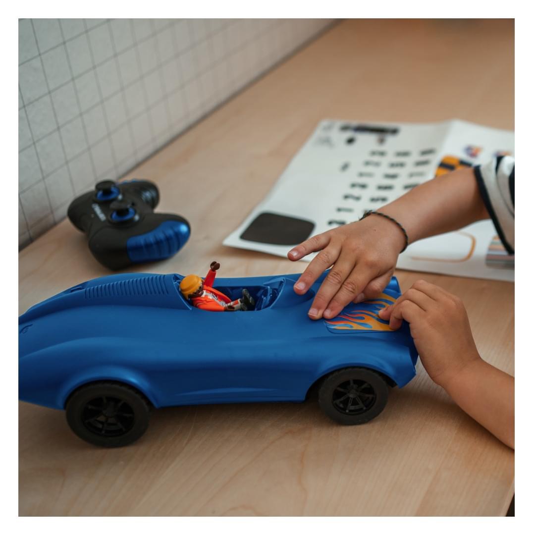 Carro de brinquedo azul com boneco e rodas pretas