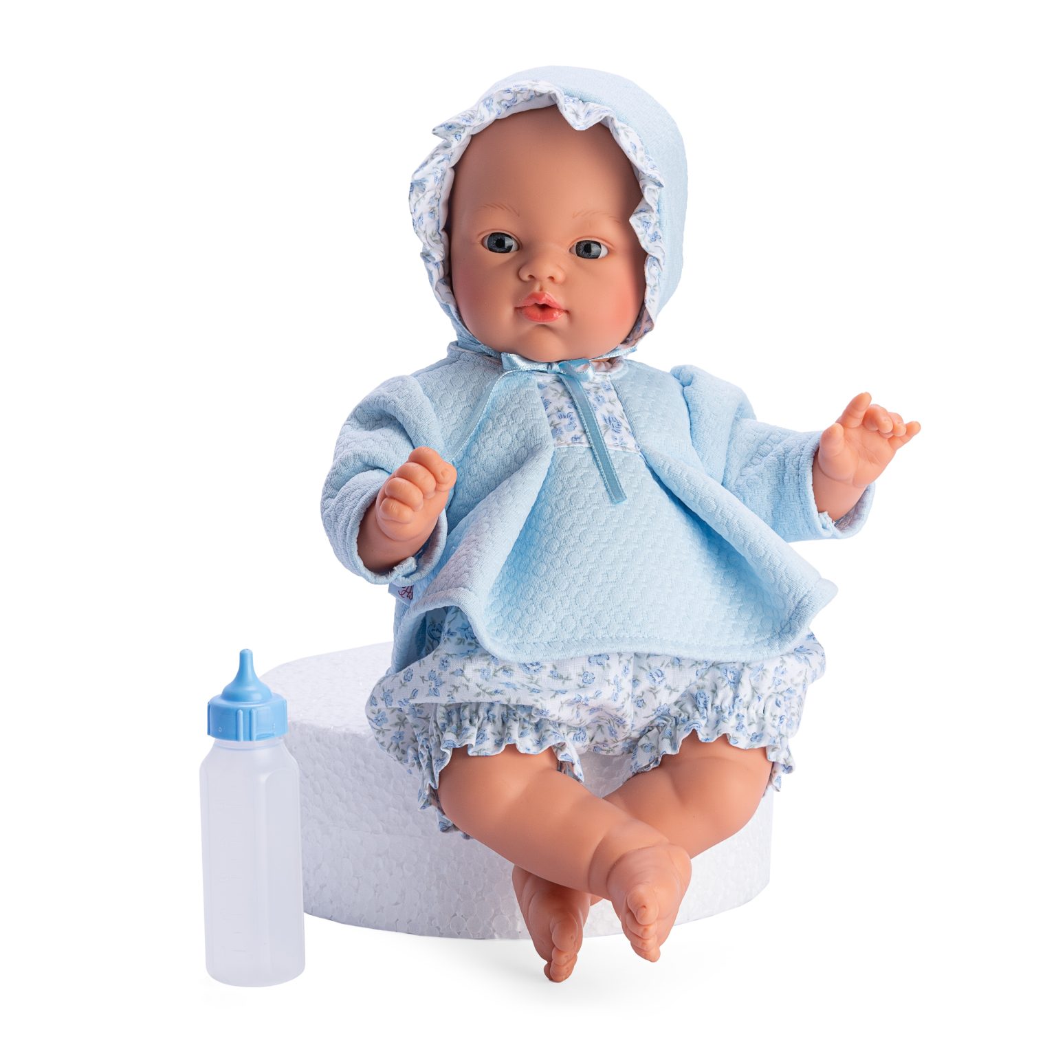 Boneca vestida de azul com chapéu branco e mamadeira ao lado