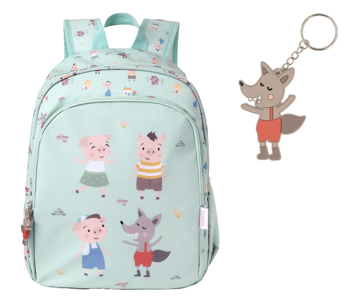 Mochila infantil azul clara com desenhos de porquinhos e lobo, ao lado chaveiro de lobo.