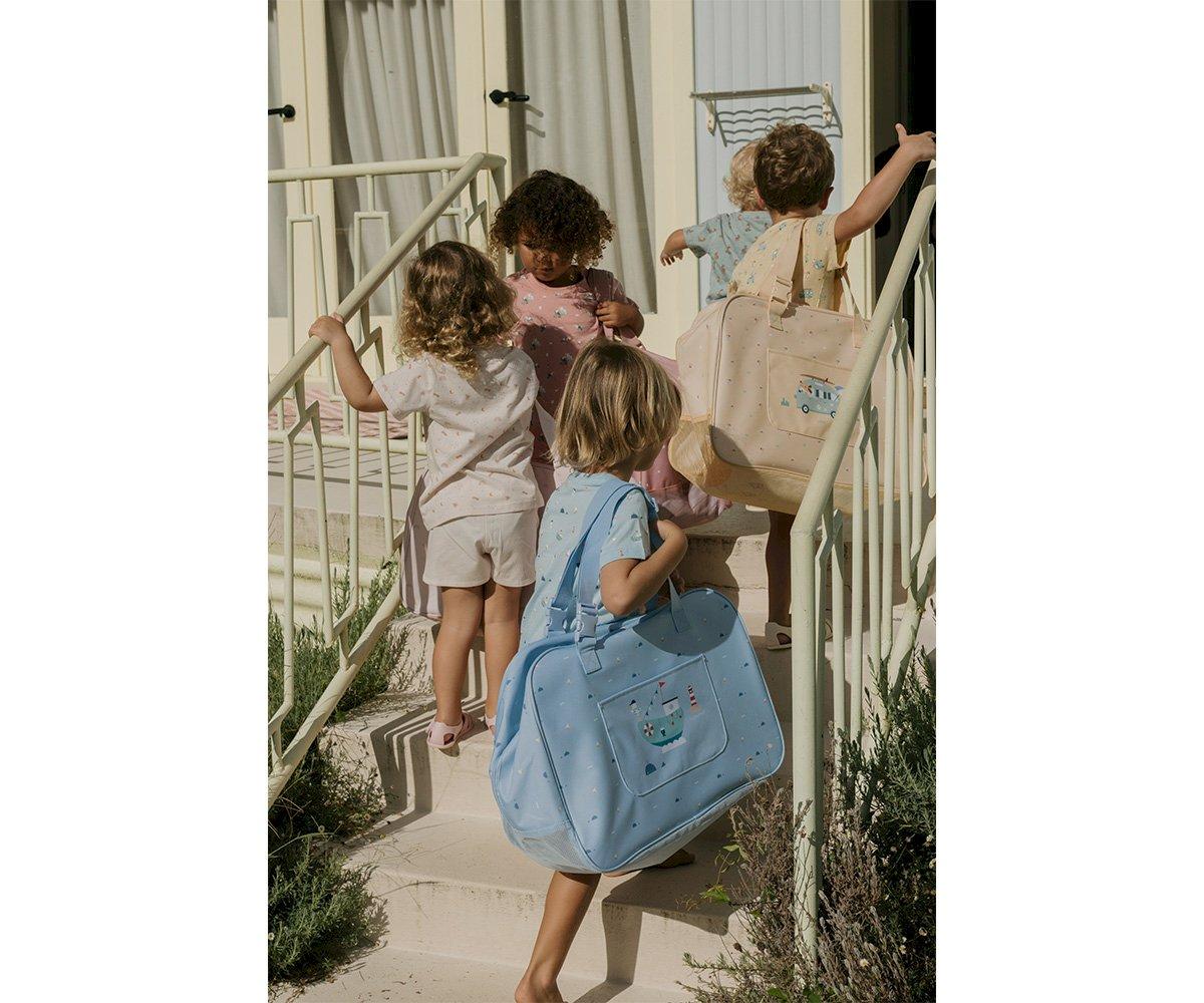 Crianças sobem escada exterior carregando mochilas de tecido coloridas