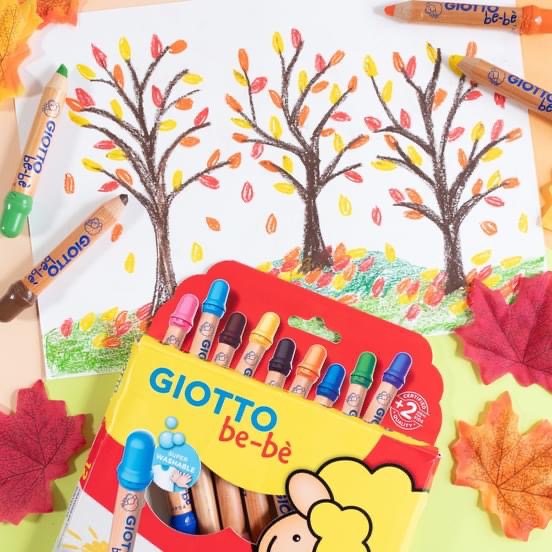 Caixa de lápis de cera GIOTTO be-bè com 10 cores ao lado de desenho de árvores e folhas artificiais