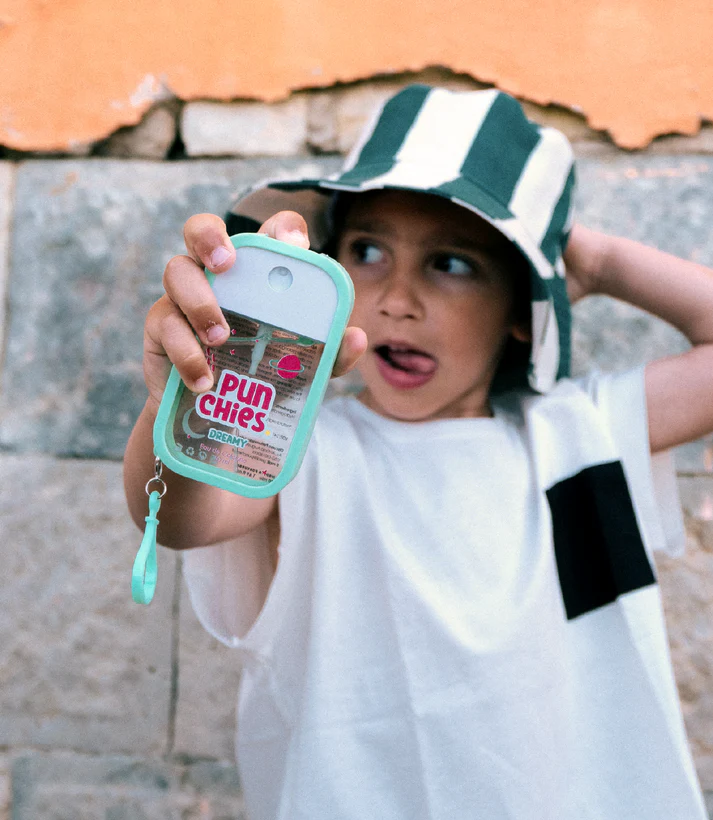 Criança com t-shirt branca e chapéu de riscas a segurar embalagem transparente PUN Chies