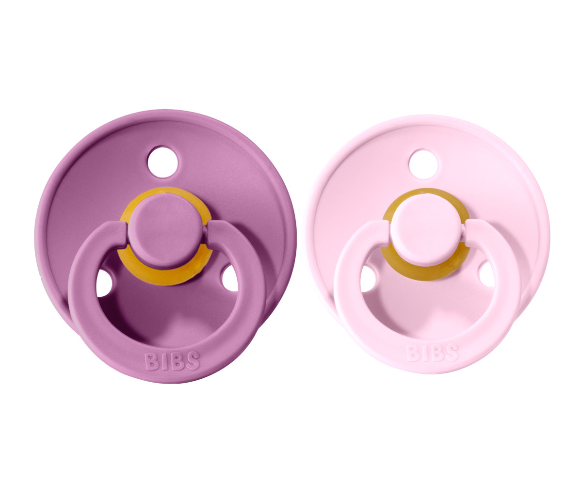 Dois chuchas BIBS, uma roxa e uma rosa, com aro circular e botão central