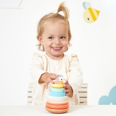 Criança brincando com brinquedo de empilhar colorido de madeira