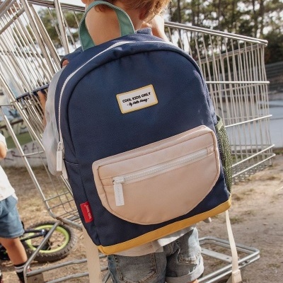 Mochila escolar azul com bolso bege e etiqueta 'COOL KIDS ONLY'