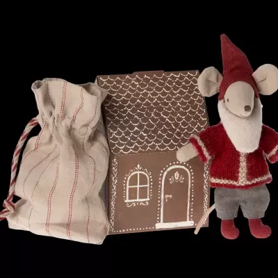 Bolsa de pano bege com riscas vermelhas, casinha decorativa castanha com padrões brancos e boneco de rato vestido com casaco e chapéu vermelhos e calças cinzentas