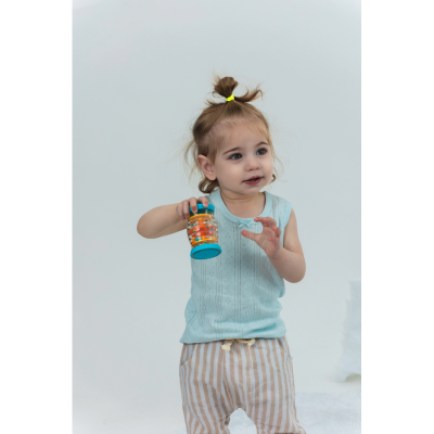 Criança com camisola azul e calças listradas segurando garrafa colorida