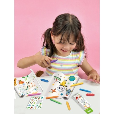 Livro de colorir infantil com gizes de cera coloridos sobre mesa branca e fundo rosa